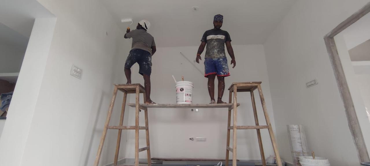 Painters finishing interior walls during construction